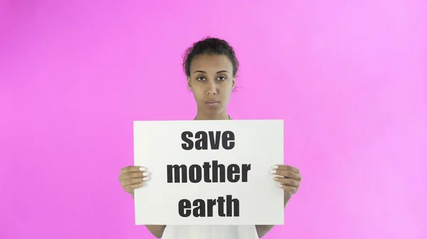 Афро-американская девушка-активистка с плакатом "Спаси мать-Землю" на розовом фоне — стоковое фото