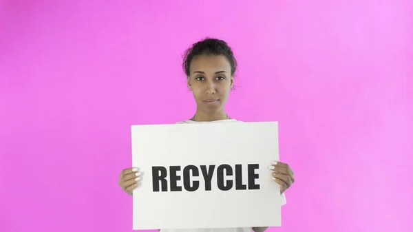 Афроамериканская девушка-активистка с плакатом "Recycle" показывает большой палец на розовом фоне — стоковое фото