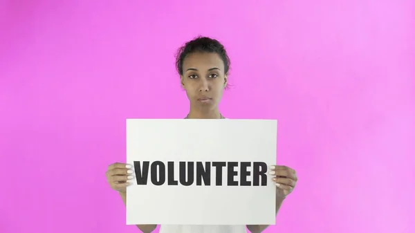 Afro-americano menina ativista com cartaz voluntário no fundo rosa — Fotografia de Stock