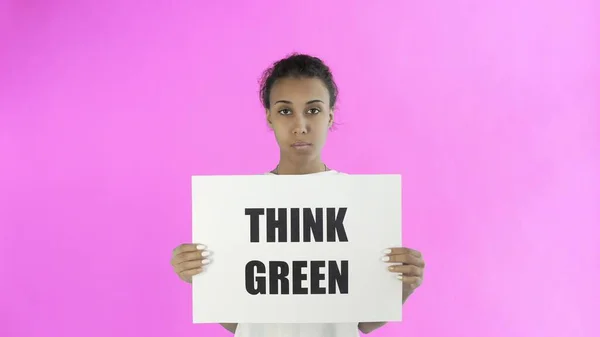 Activista afroamericana con afiche Think Green sobre fondo rosa — Foto de Stock