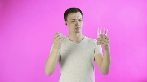 Activista joven activista con vasos de plástico y vidrio sobre fondo rosa — Foto de Stock