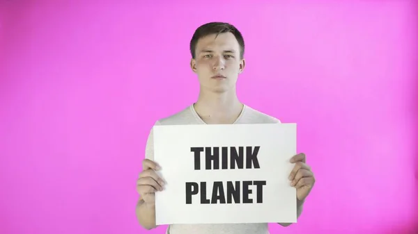Молодой человек-активист с плакатом Think Planet на розовом фоне — стоковое фото