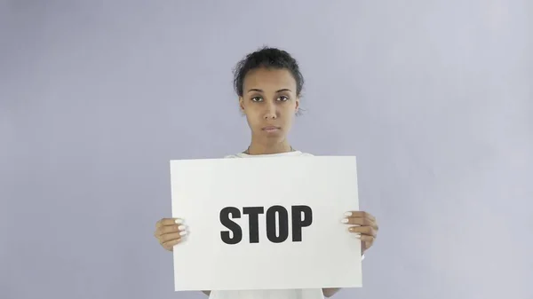 Афро-американская девушка-активистка с остановкой плакат на сером фоне — стоковое фото