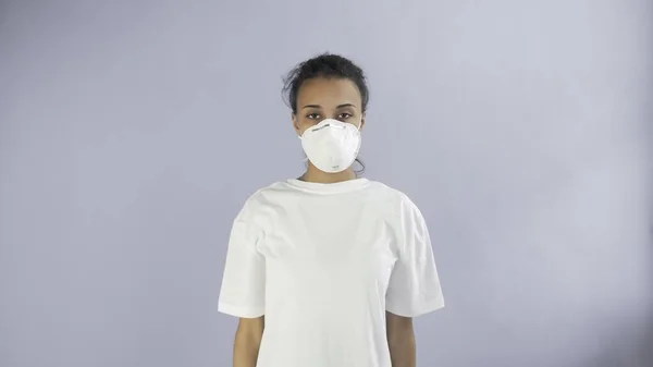 Joven afro-americana chica usando mascarilla en fondo gris — Foto de Stock