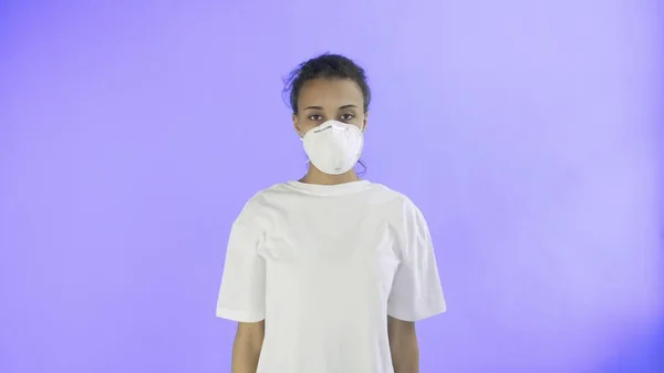 Joven activista con máscara en la cara sobre fondo violeta —  Fotos de Stock