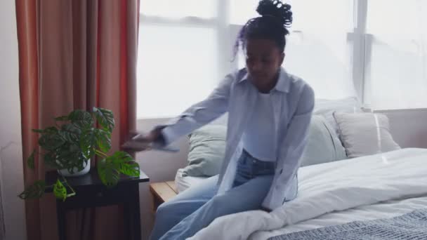 Attrayant jeune femme afro-américaine s'assoit dans le lit et lit le livre — Video