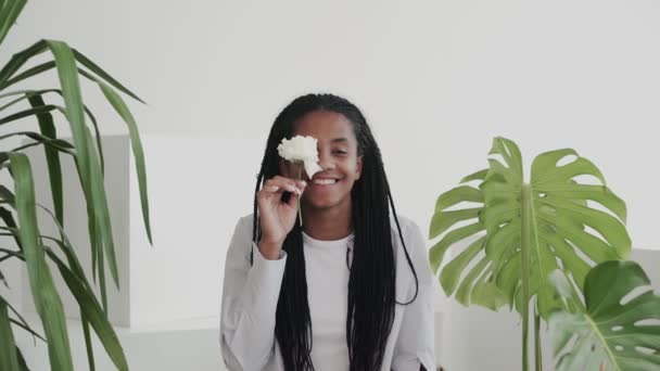 Aantrekkelijke mooie Afrikaanse Amerikaanse vrouw model met bloemen op zoek en poseren op camera — Stockvideo