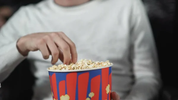 Hombre comiendo palomitas de maíz en el cine y viendo la película . — Foto de Stock