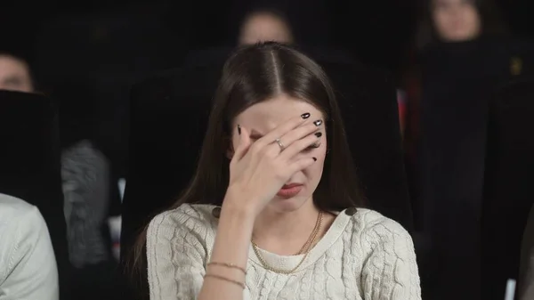 Gros plan d'une jeune femme effrayée utilisant ses mains pour couvrir son visage tout en regardant un film effrayant. — Photo