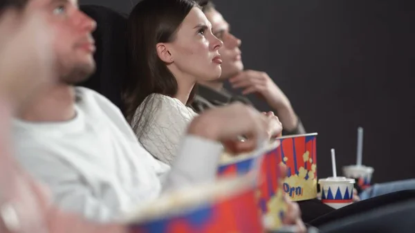 Amigos no cinema assistindo filme bebendo cola e comendo pipocas . — Fotografia de Stock