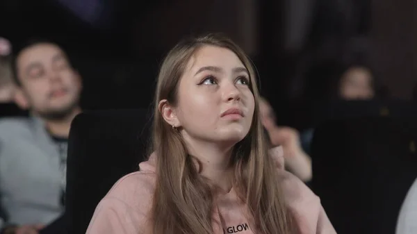 Молодая женщина смотрит кино в кино. эмоция - интерес — стоковое фото