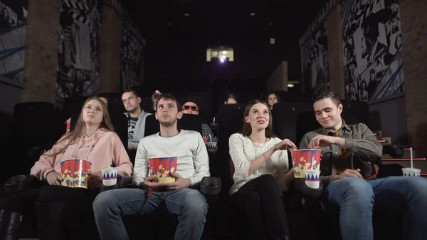 Junge Leute lachen über Komödien im Kinosaal. Junge Leute lachen im Kino und sehen amüsante Komödie. — Stockfoto