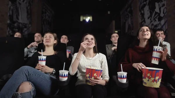 Três amigas bonitas estão assistindo a um filme camedy . — Fotografia de Stock