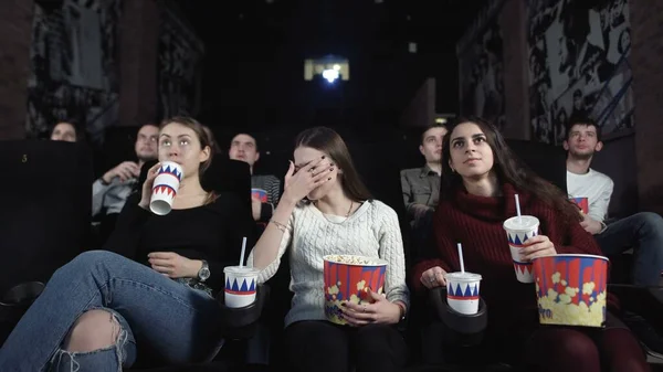 Tres amigas guapas están viendo una película aterradora.La mujer media reacciona con conmoción . — Foto de Stock