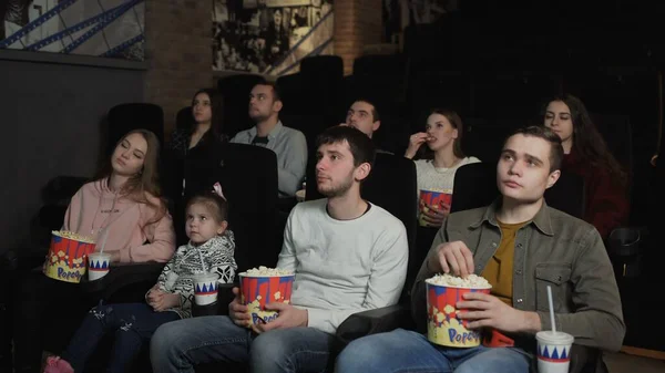 La gente come palomitas de maíz y ve una película en el cine — Foto de Stock