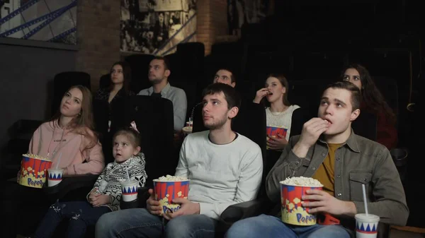 La gente come palomitas de maíz y ve una película en el cine — Foto de Stock