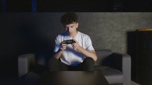 Přední pohled na mladého muže hrajícího videohry na gauči doma — Stock video
