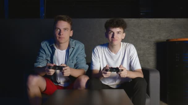 Два геймера перед экраном играют вместе в онлайн-битве — стоковое видео