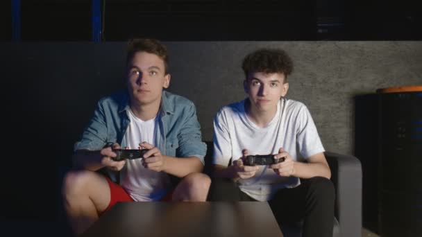 Två ANGRY killar sitter på soffan framför TV:n och förlorar i ett spel på konsolen — Stockvideo