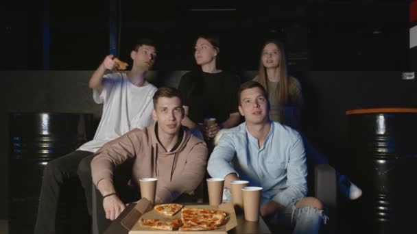 Groupe d'amis regardant à la télévision un match de football ils soutiennent leur équipe préférée tout en buvant de la bière et en mangeant de la pizza — Video