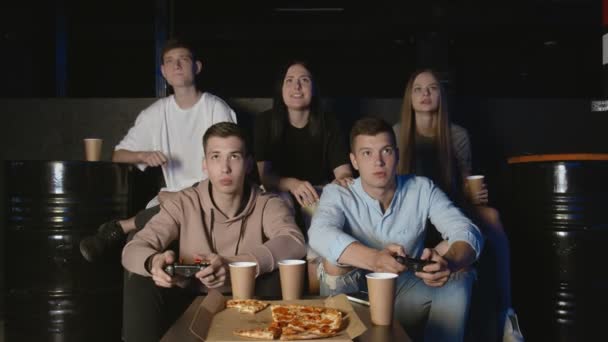 Группа расстроенных друзей отдыхает на диване в гостиной и играет в видеоигры. — стоковое видео