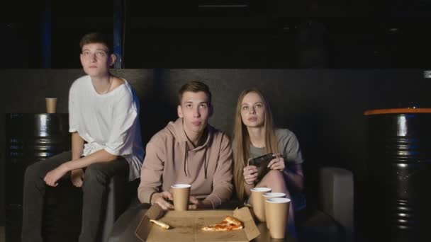 Video oyunu oynayan ve evde pizza yiyen mutlu bir arkadaş grubu. — Stok video