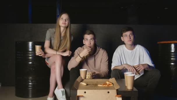Bästa vänner äter popcorn och chips tittar på film eller tv-program hemma. Människor, vänskap och livsstil — Stockvideo