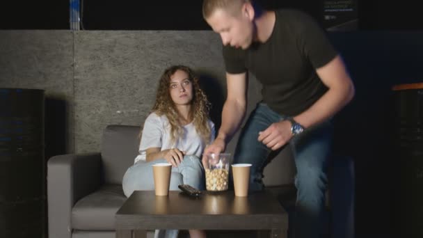 Mutlu Rahat Çift, TV 'de birlikte oturup patlamış mısır yiyor. — Stok video