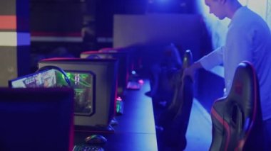 Genç erkek oyuncu çevrimiçi video oyunu eSport Tournament Arena 'ya giriyor. Ve masaya oturur.