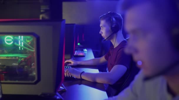 Dos deportistas cibernéticos profesionales juegan un juego en línea en un club de informática. — Vídeos de Stock
