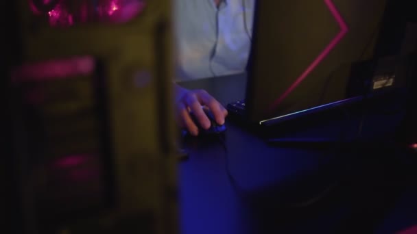 Joven concentrado se sienta frente al monitor y juega duro nivel en el videojuego en el club de computadoras — Vídeo de stock