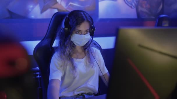 Geconcentreerde vrouw in het gezicht maskers speelt in Video Games in Moderne computer club. — Stockvideo