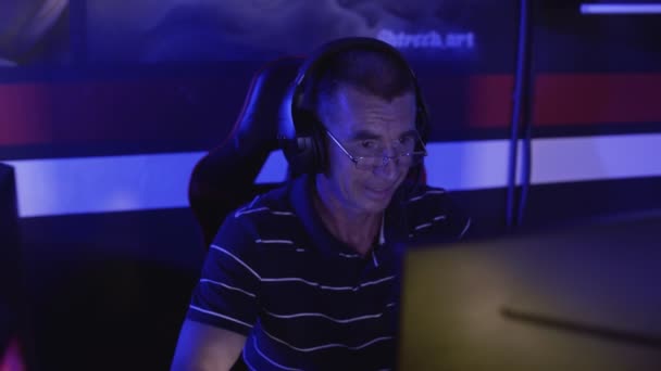 Старий гравець емоційно грає і виграє в комп'ютерній грі — стокове відео