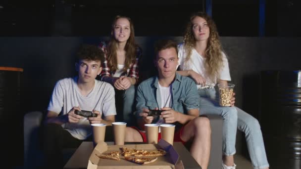 友人のコンソールパーティー。二人の男性の友人がビデオゲームで勝つ,ソファに座って — ストック動画