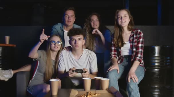 Jovem homem feliz completa o nível duro no jogo de vídeo. Divertir-se com amigos . — Vídeo de Stock
