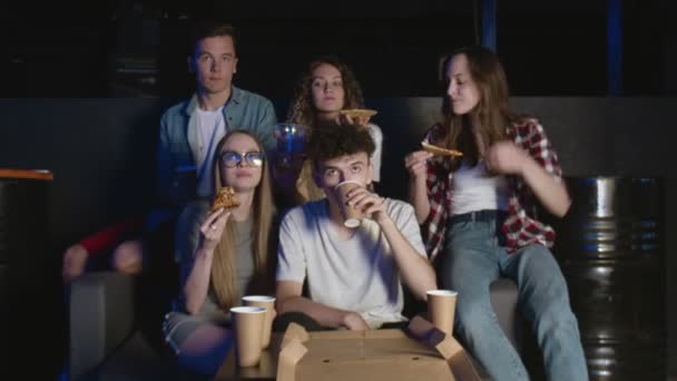 Estudantes assistindo filme e comendo pizza à noite em casa — Vídeo de Stock