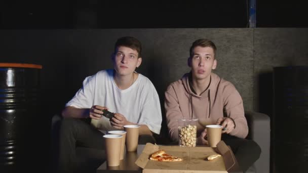 Due amici maschi che vincono nel videogioco, seduti sul divano, amicizia adolescenziale — Video Stock