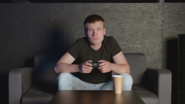 Upset man after losing at online video games sitting on couch — Stock Video