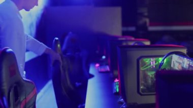 Genç erkek oyuncu çevrimiçi video oyunu eSport Tournament Arena 'ya giriyor. Ve masaya oturur.