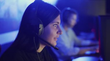Yakın plan bir kadın bir bilgisayar kulübünün koridorunda oturuyor ve online bir oyun oynuyor. Modern bilgisayar kulübü.