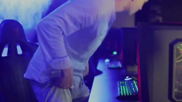 Joven jugador Pro Sentado en su ordenador y encendiendo el monitor — Vídeos de Stock