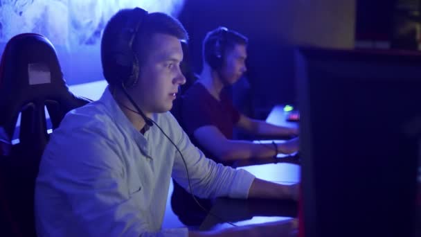 Dos jóvenes jugadores masculinos en auriculares jugando y perdiendo en el videojuego en línea eSport Cyber Games Concept. — Vídeos de Stock