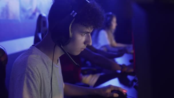 젊은 남자 현대 전자 스포츠 클럽에서 슈팅 비디오 게임을 하며 시간을 보내는 — 비디오