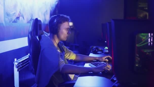 Homem concentrado jogando em videogame online no moderno clube de ciberesporte e-sport — Vídeo de Stock