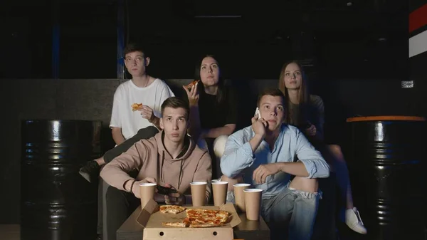 Unga män som har kul med tv-spel på fest i huset medan vänner tittar — Stockfoto