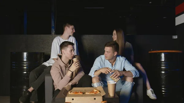 Retrato de jóvenes amigos que comen palomitas de maíz durante el juego deportivo en la televisión y hablando de las acciones de los jugadores — Foto de Stock