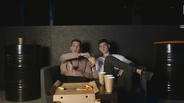 Im Wohnzimmer zwei beste Freunde vor dem Fernseher und essen Popcorn — Stockfoto