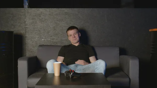 Young man playing console game in front of camera, beating his opponent online. White man on sofa. — Stock Photo, Image