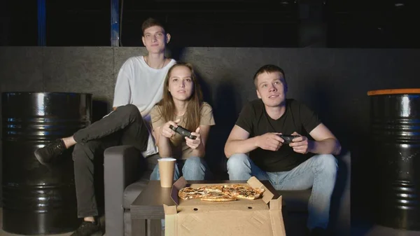 Glückliche Freunde Jungs und Mädchen spielen Videospiel zu Hause in der Nacht Spaß lachen mit Joysticks sitzen auf dem Sofa zusammen — Stockfoto