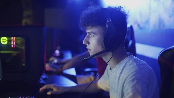Genç adam kulaklık takıyor ve bir video oyununda oynamaya hazırlanıyor. — Stok fotoğraf